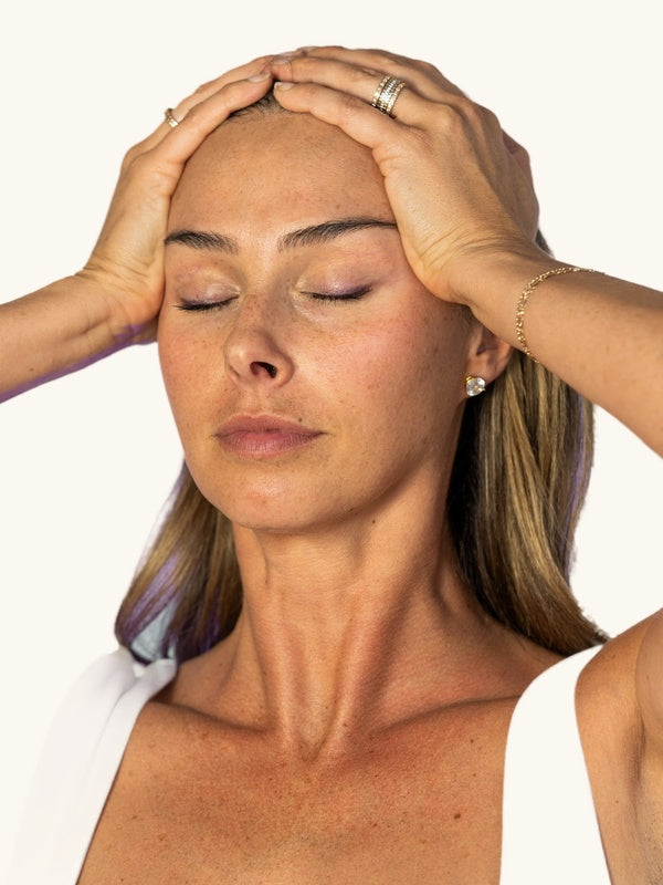 Ryan demonstrating The Unfurrowing, hands resting at her temples